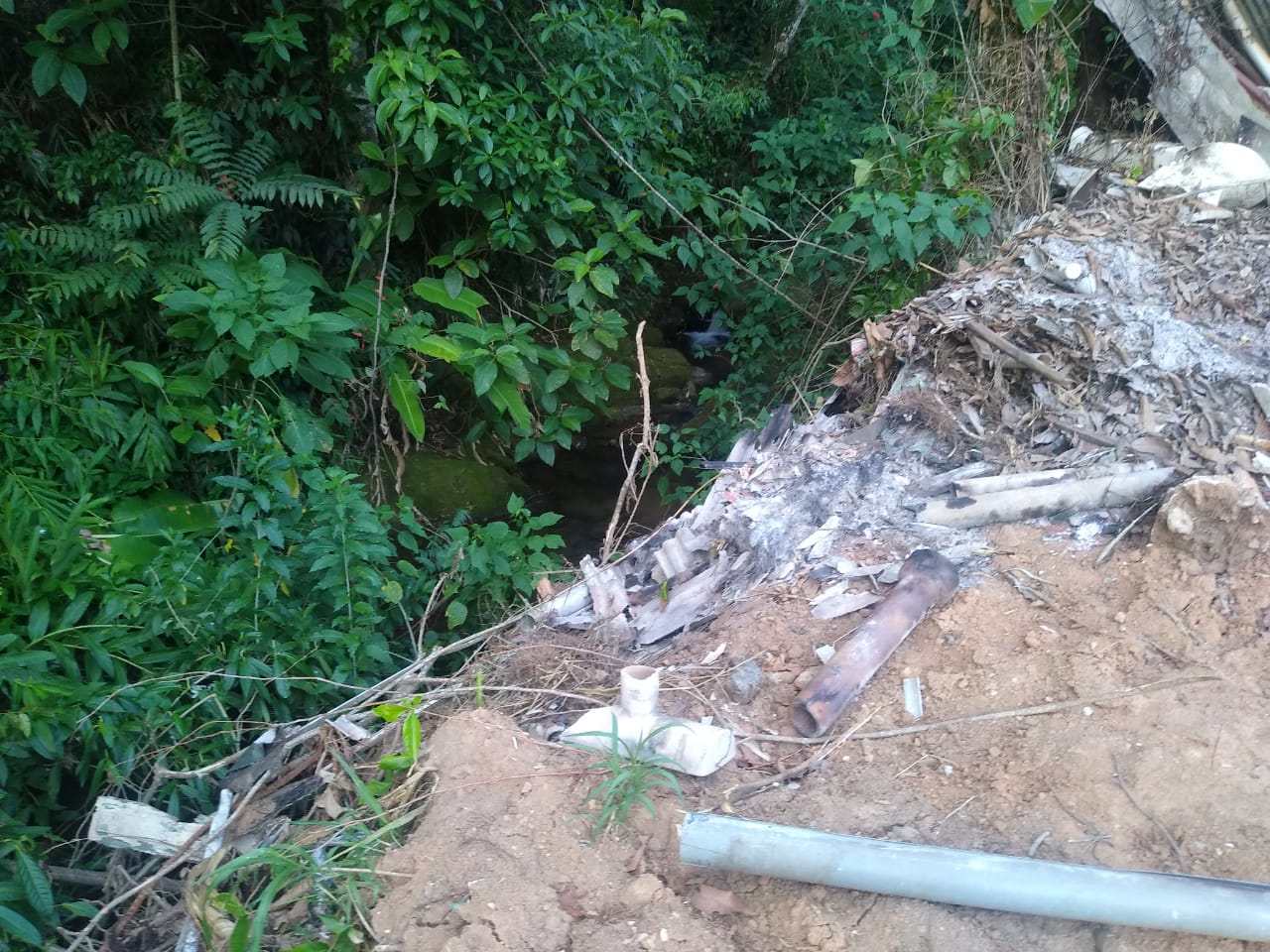 Materiais como cascalho e lixo jogados dentro de córrego são localizados após denúncia de crime ambiental em Mangaratiba